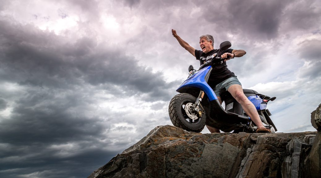 man in black jacket and blue denim jeans riding blue and white motorcycle