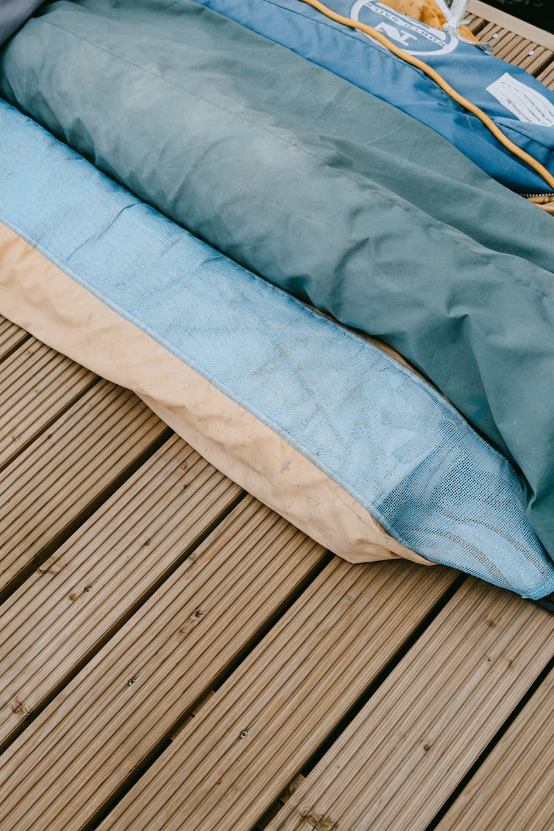Stacked boat covers on a wooden dock, showcasing vibrant colors and nautical themes.